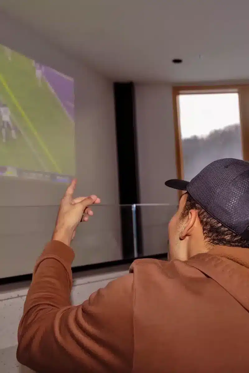 Man watching sports on projector screen at Drifters watch party at Bousquet Mountain