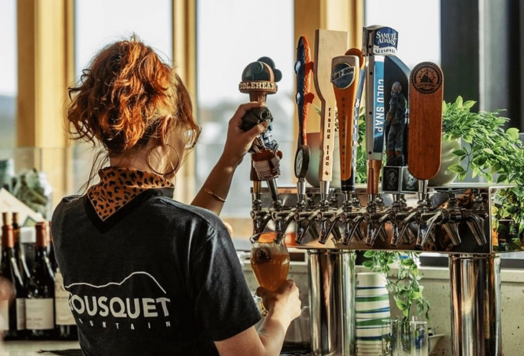 Woman pouring a beer on draft at Drifters at Bousquet Mountain
