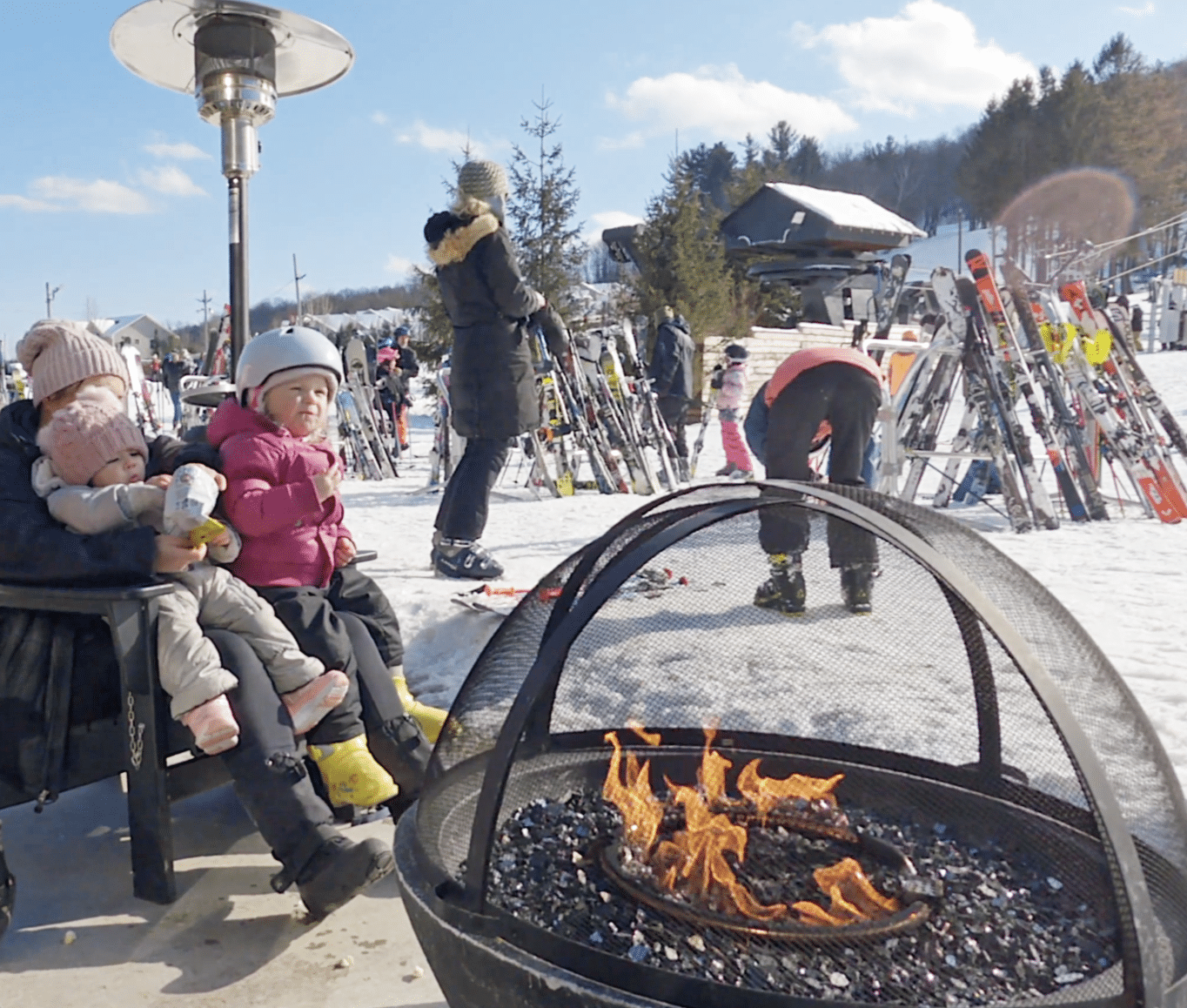 Family sitting at bonfire outside of Bousquet Mountain lodge